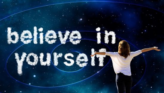 Woman standing with her arms spread wide in front of text saying Believe In Yourself