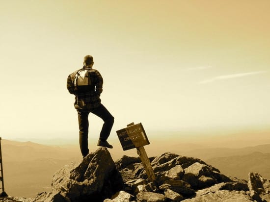 Man staning on top of Mount Washington Man staning on top of Mount Washington