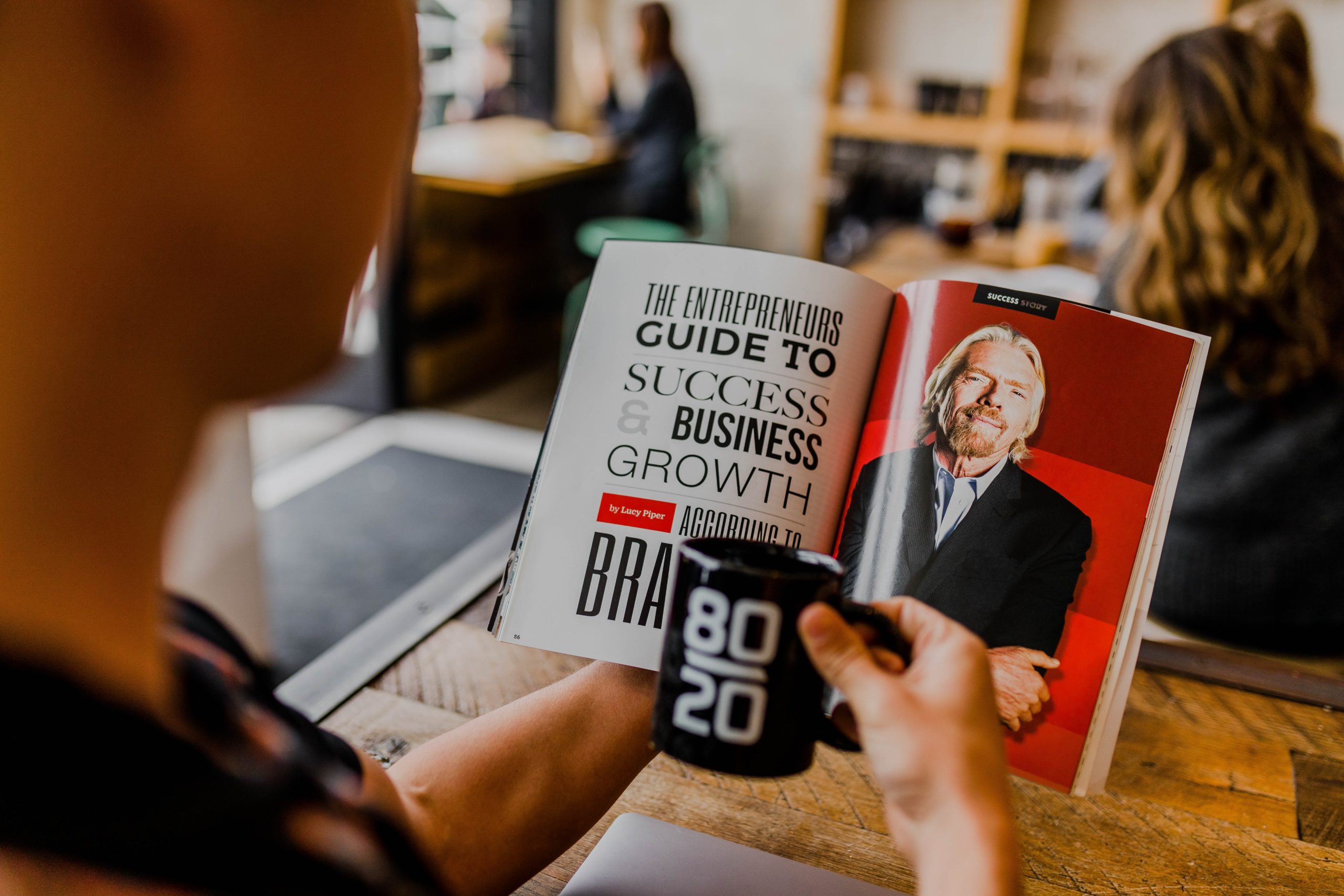 Man reading a magazine article about Richard Branson