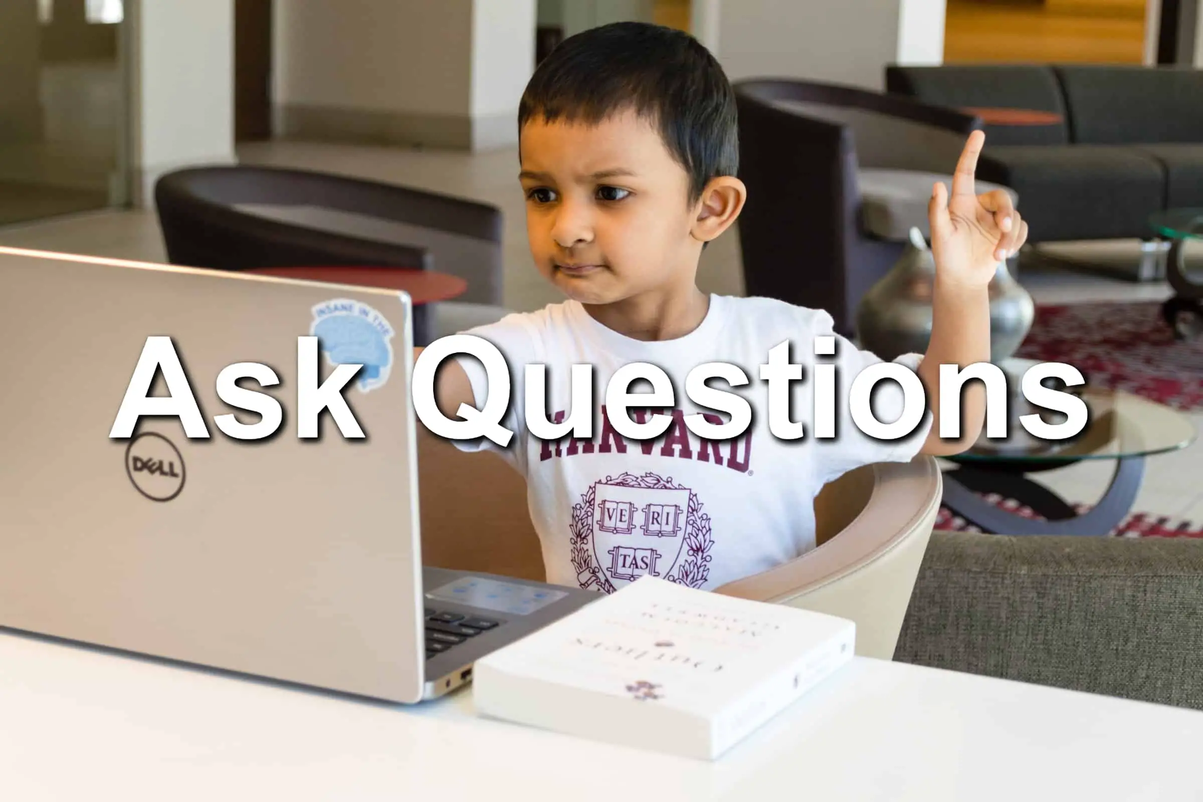 A child on a Dell laptop stopping to ask a question