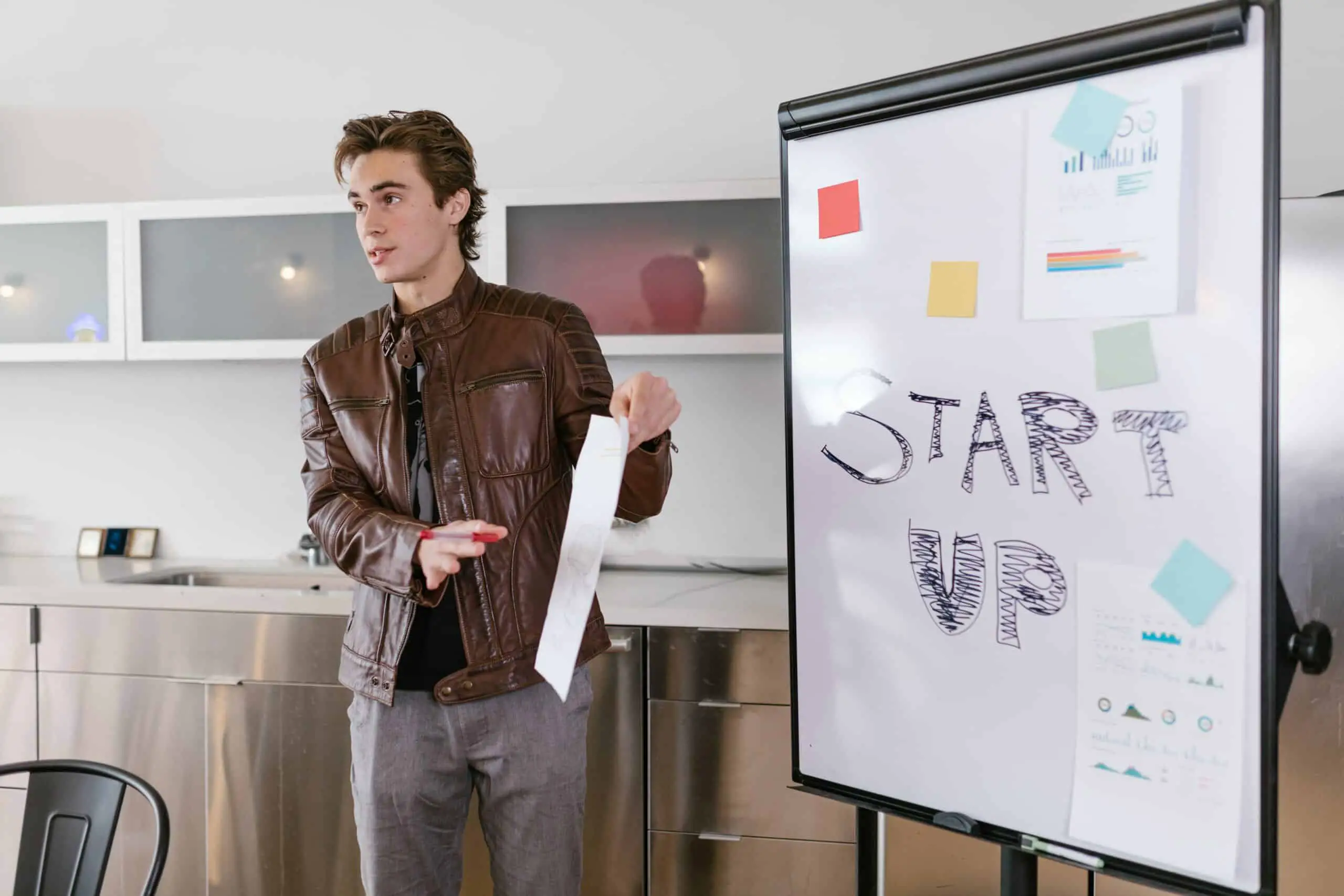 Man standing in front of a white board that says START UP