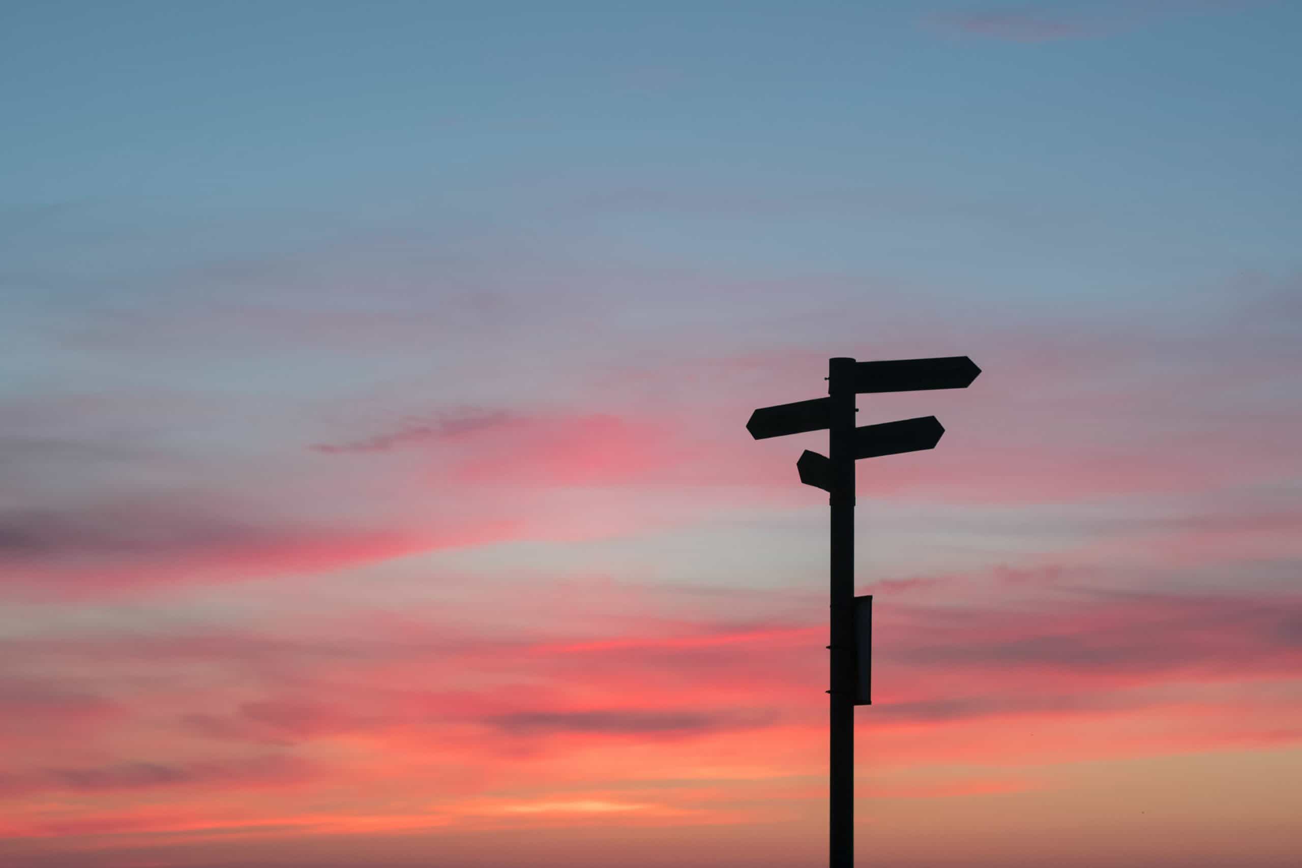 Street sign with a purple and yellow sunset