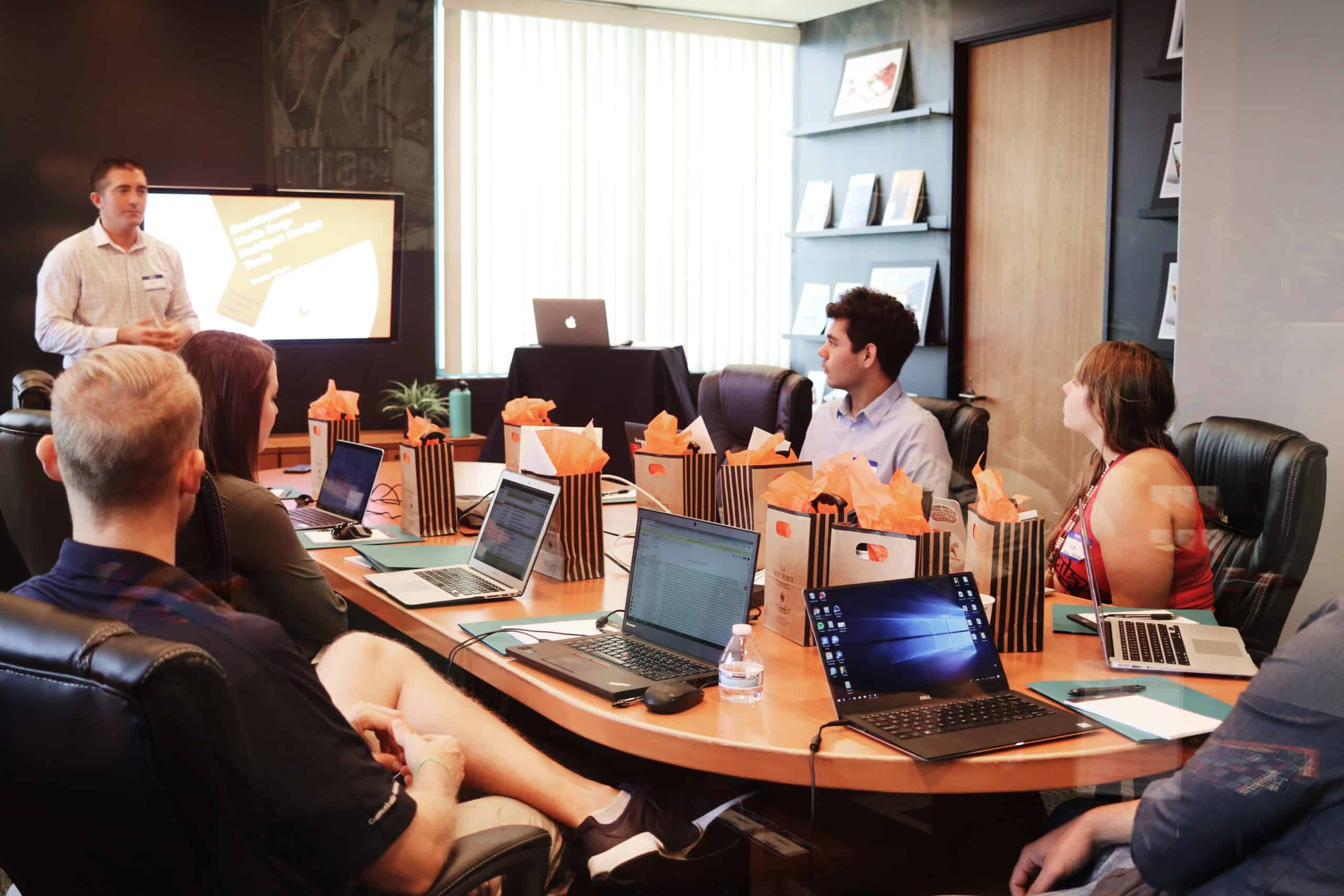 People sitting around a table listening to a presentation