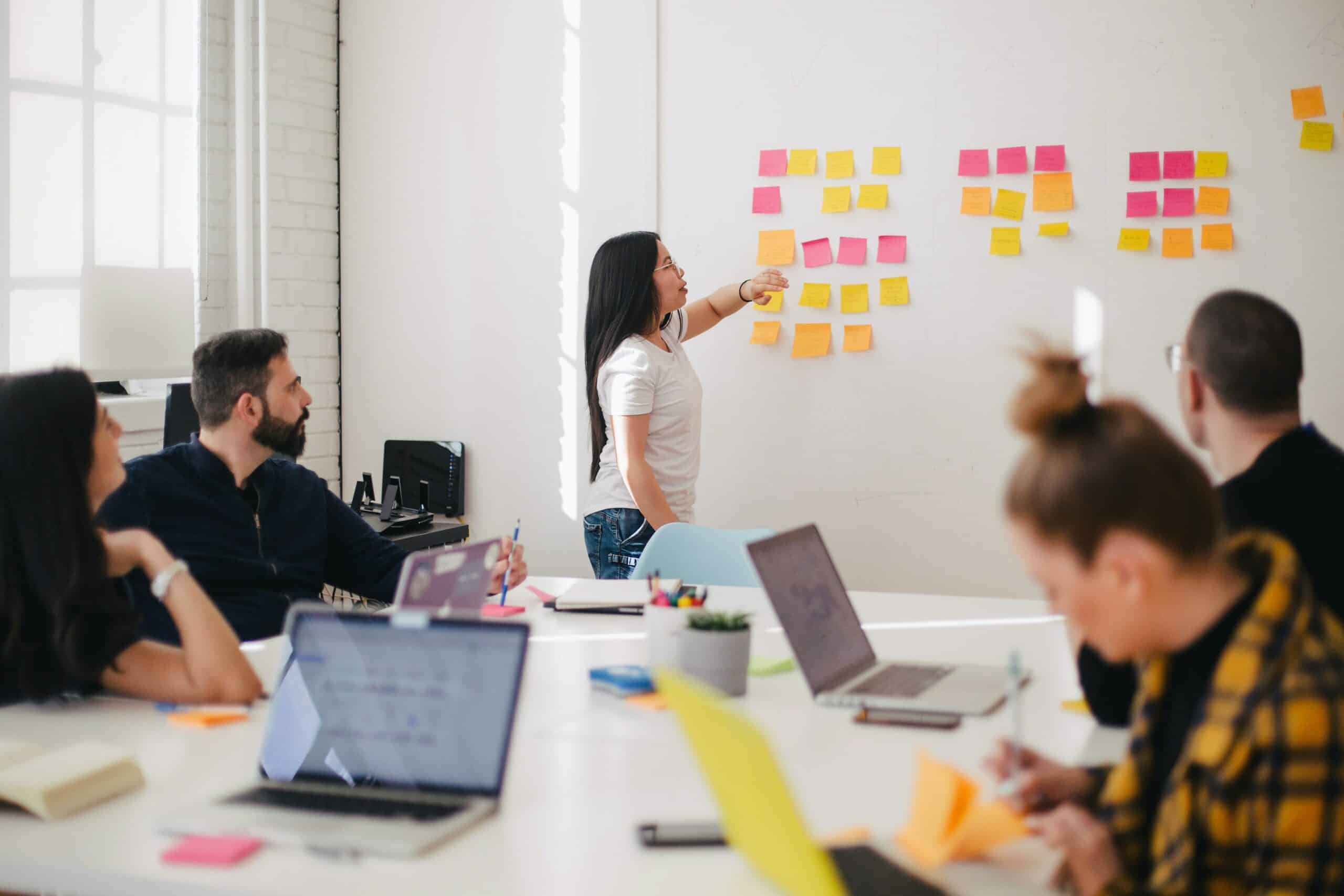 Woman placing a sticky note on a whiteboard