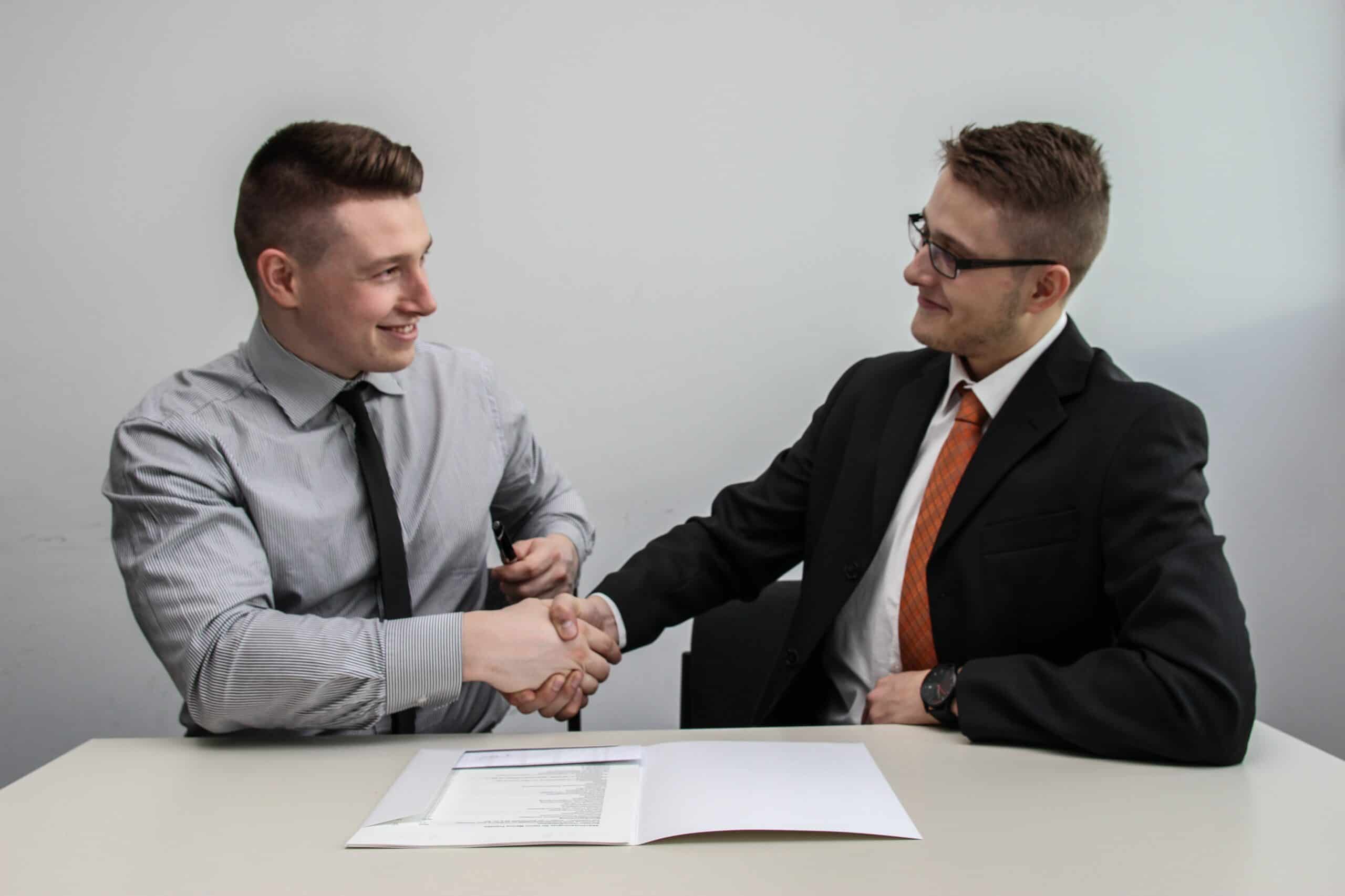Men in business suits shaking hands.