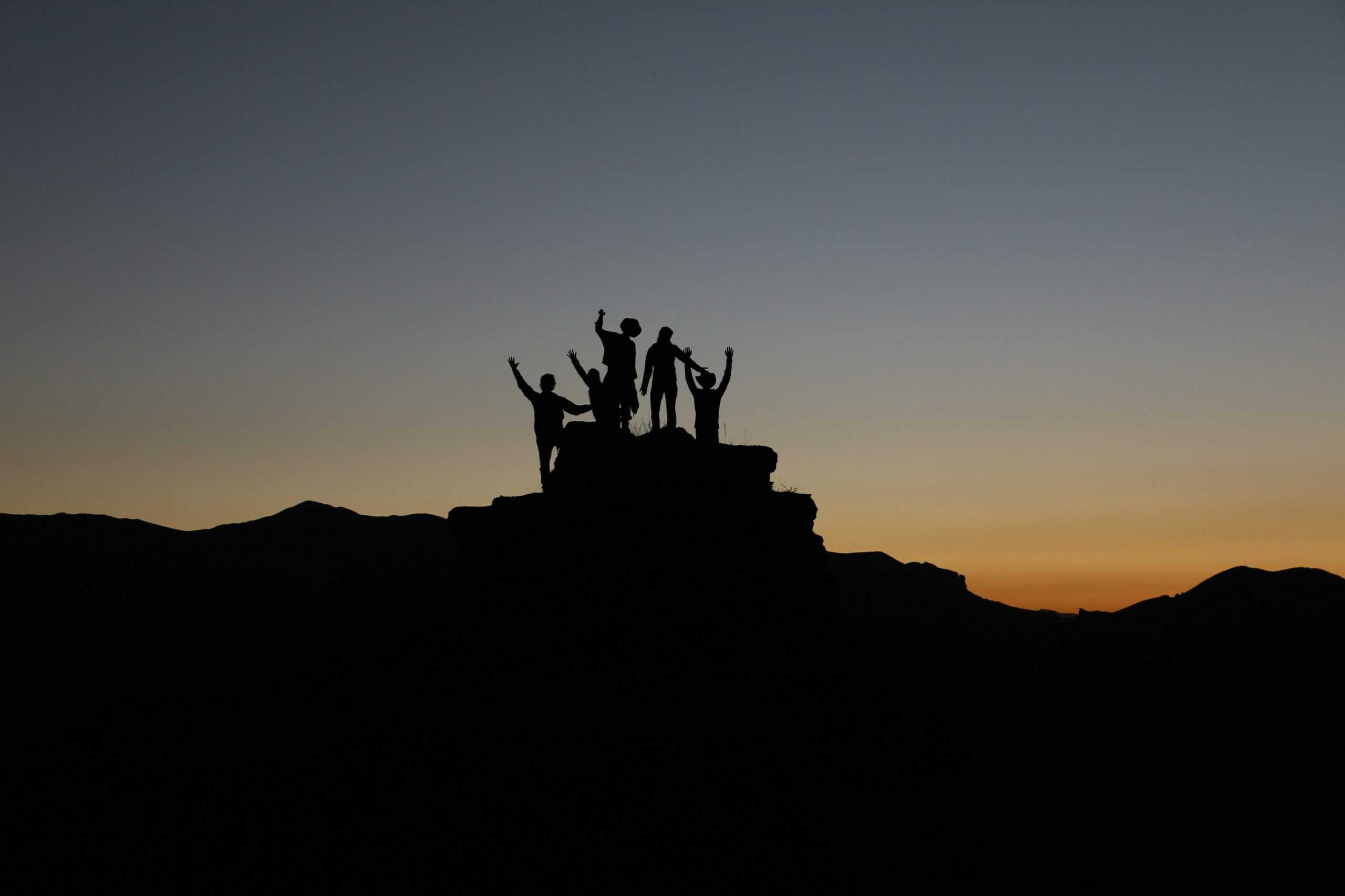 Group of people celebrating on the top of a rock formation