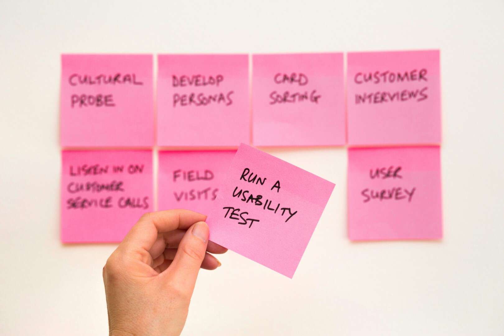 Person looking at pink sticky notes